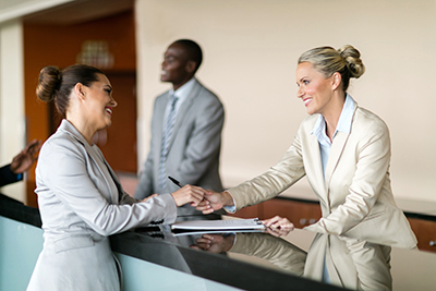 Two women shaking hands at counter